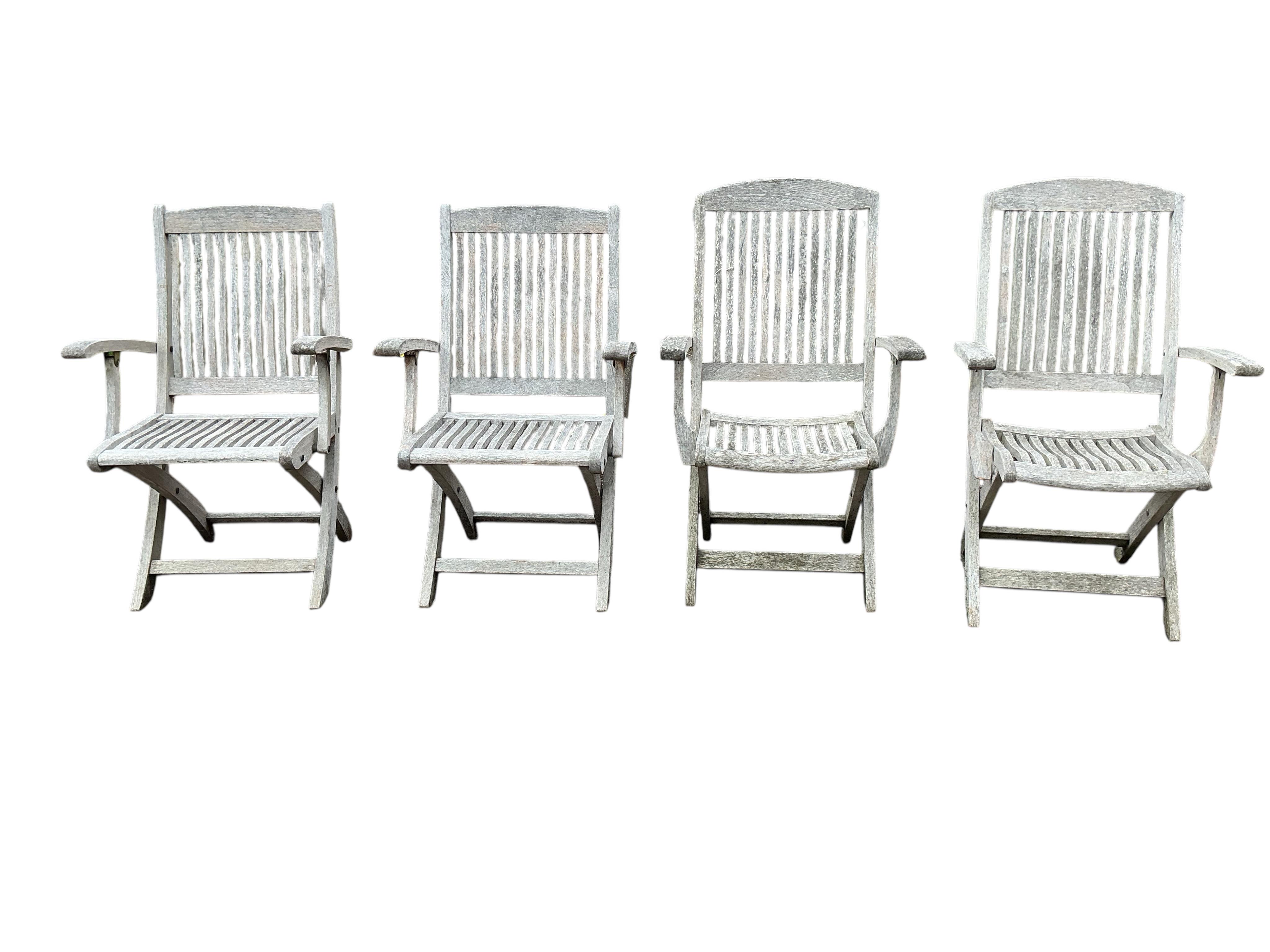 An Indian Ocean Trading Company rectangular teak extending garden table, width 164cm, depth 90cm, height 74cm, four folding chairs and a canvas parasol with metal stand